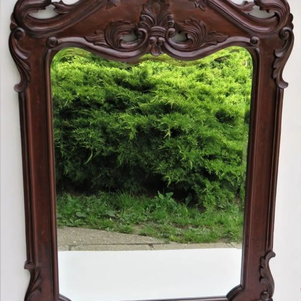 Vyřezávaný rám s fazetovým zrcadlem.